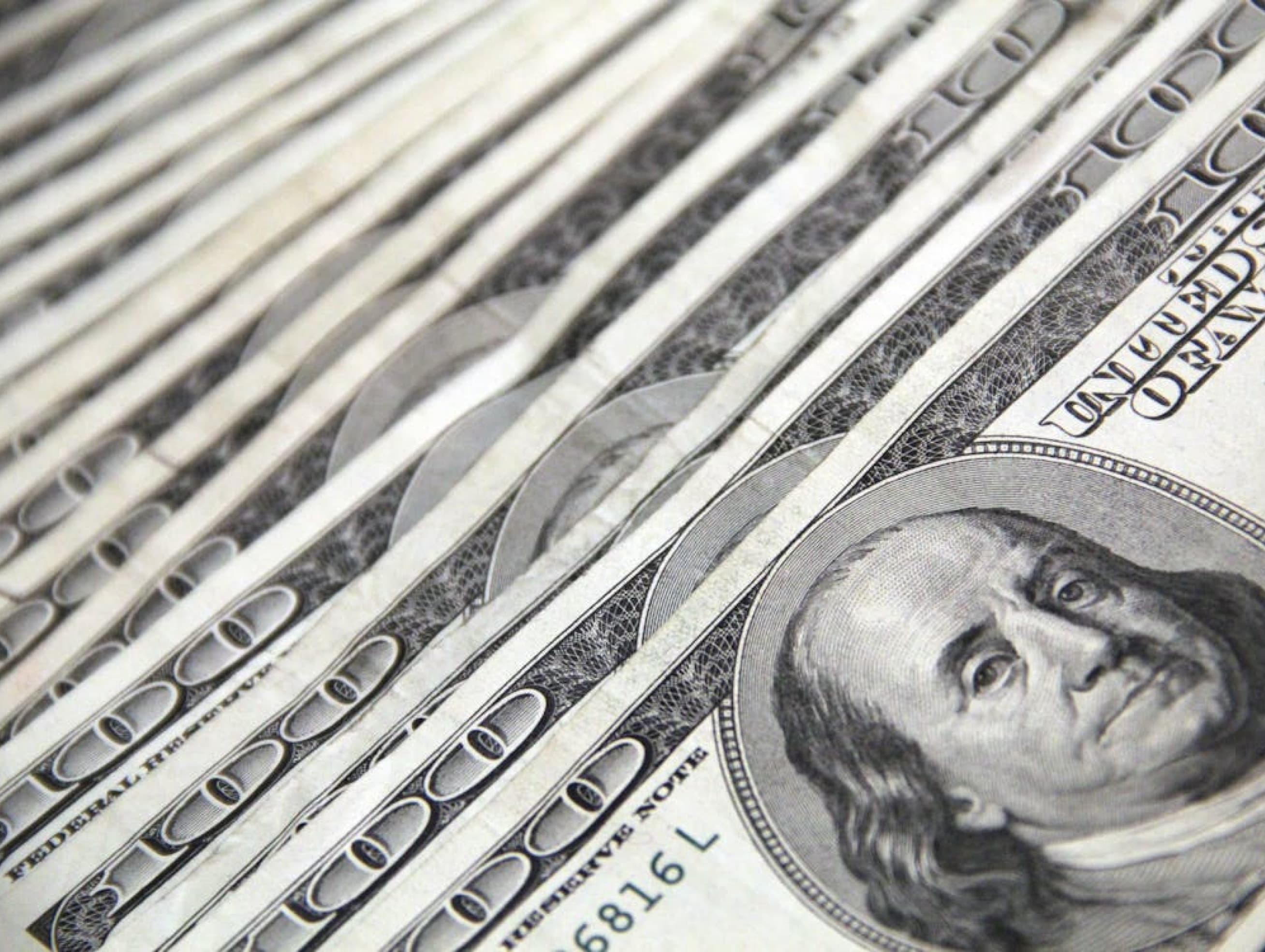 Stack of hundred-dollar bills visualizing rising homeowner insurance costs in the U.S.